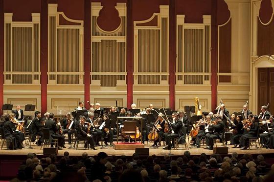 Photo of the Pittsburgh Symphony Orchestra performing on stage. 